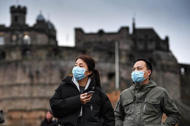 Tourists wear face masks as they visit Edinburgh Castle on January this year (Picture: Jeff J Mitchell/Getty Images)