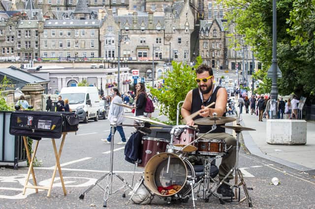 A busker takes advantage of the lack of traffic on Waverley Bridge to perform (Picture: Lisa Ferguson)