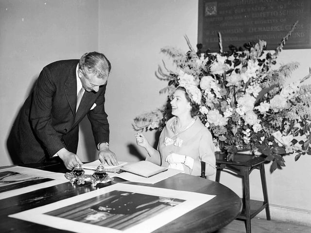 Queen Elizabeth II signing the visitors' book of Scotland's oldest boarding school, Loretto School, which is situated just outside Edinburgh, in Musselburgh, on July 1 1958.