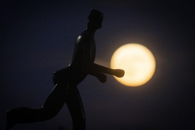 A sculpture of jogger is silhouetted against supermoon in Zagreb, Croatia. (AP Photo/Darko Bandic)
