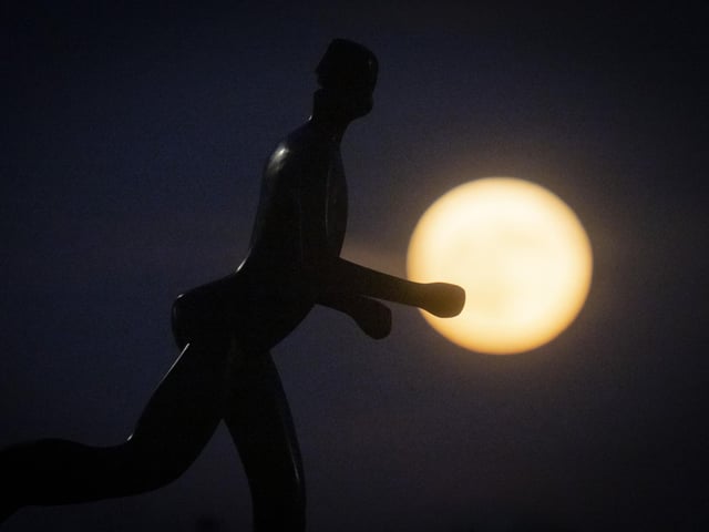 A sculpture of jogger is silhouetted against supermoon in Zagreb, Croatia. (AP Photo/Darko Bandic)