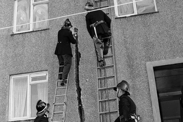 Firemen chip a 12ft hole in the wall of a house while fighting a blaze in Dalkeith in October 1964.