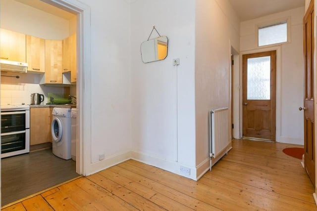The entrance hallway has traditional wooden floorboards and two spacious storage cupboards.