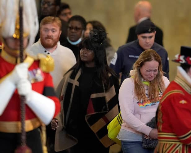 Members of the public pay their respects as they pass the coffin of Queen Elizabeth II inside Westminster Hall (Photo by MARKUS SCHREIBER/POOL/AFP via Getty Images)