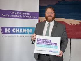 Owen Thompson MP holds a sign to show support for the IC Change Campaign to end violence against all women. Photo by Kiki Streitberger