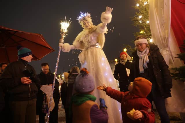 A theatrical performer on stilts delights children on the first day of the Christmas market in Berlin, Germany. (Photo by Sean Gallup/Getty Images)
