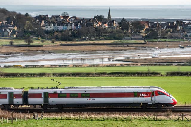 An LNER Azuma passes the colourful houses of Alnmouth