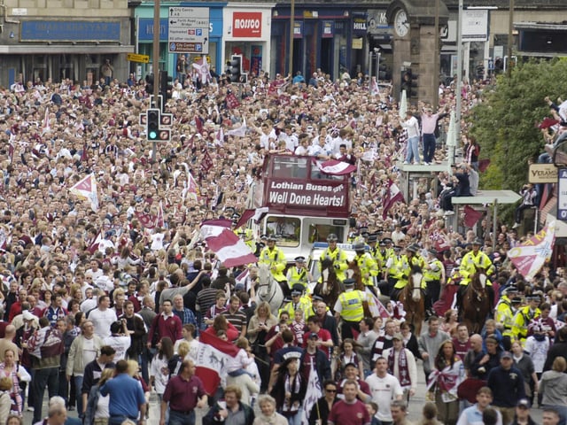 The Hearts team is welcomed back to Edinburgh by thousands of Jambos after beating Gretna in the Scottish Cup final in 2006. The team is pictured on an open top bus with the trophy at Haymarket on route to their home in Gorgie.