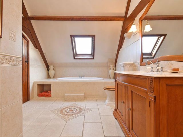 Here's the master en-suite/family bathroom - the bath is set beneath a Velux window, plus there is a separate shower enclosure and a wash basin with a marble top.