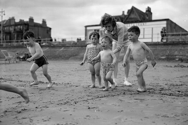 A mum persuades her little boy to go into the sea at Portobello Beach in summer 1961.