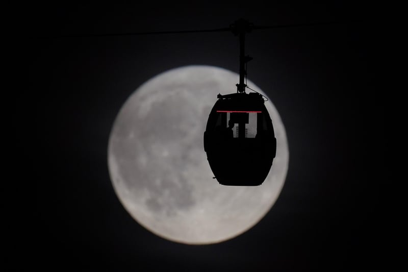 People view the super blue moon as they travel in a IFS Cloud Cable Car at Greenwich.