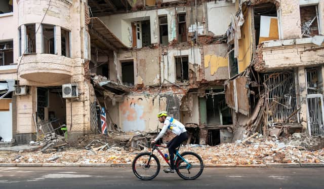 A cyclist rides past a building partially destroyed by a missile strike in the centre of Kharkiv, amid the Russian invasion of Ukraine (Picture: Sergey Bobok/AFP via Getty Images)