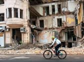 A cyclist rides past a building partially destroyed by a missile strike in the centre of Kharkiv, amid the Russian invasion of Ukraine (Picture: Sergey Bobok/AFP via Getty Images)