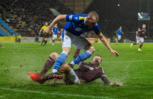Hearts' Andy Halliday tackles St Johnstone's James Brown in the rain at McDiarmid Park.