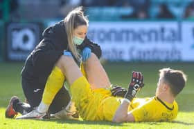 Hibs goalkeeper Matt Macey receives treatment during the match against Celtic at Easter Road on Sunday