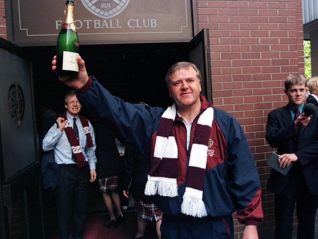 Hearts manager Jim Jeffries raises a bottle of champagne outside Tynecastle Park after breaking the club's cup hoodoo to bring home the Scottish Cup in 1998.