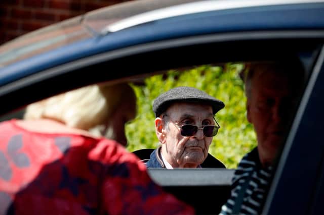 A care home resident speaks to relatives during a drive-through visit during the first weeks of the Covid pandemic (Picture: Adrian Dennis/AFP via Getty Images)