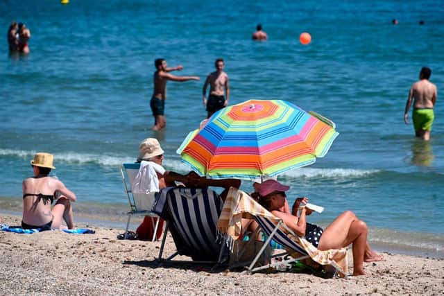 People enjoy the sun on a beach during a heatwave in Palavas-les-Flots, southern France, on June 23 as the country eases lockdown measures taken to curb the spread of the Covid-19 pandemic (Photo: PASCAL GUYOT/AFP via Getty Images)