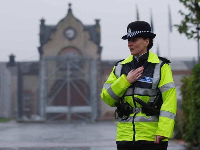 A policewoman controls access to Saughton Prison in 2002  where a disturbance broke out in Glenesk Hall after a dispute over visiting rights.