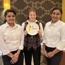 Three of The Radhuni’s front of house staff with the Rosette plate.