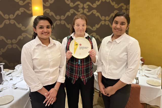 Three of The Radhuni’s front of house staff with the Rosette plate.