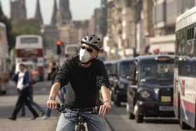 A cyclist on Prince Street wearing an air pollution mask. Pro-cycling policy in Edinburgh which impacted on bus travel on Princes Street may be scaled back under the city's new administration. PIC: Jon Savage.
