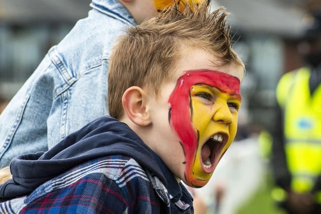 Two youngsters in face paint cheer as the horses make their way to the finish line.