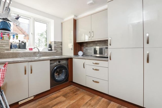 This utility room or laundry room, just off the kitchen, is a handy bonus. With space for appliances, it boasts considerable room for storage.