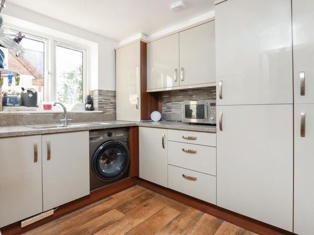 This utility room or laundry room, just off the kitchen, is a handy bonus. With space for appliances, it boasts considerable room for storage.