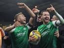 Hibs' Martin Boyle celebrates his hat-trick with the matchball and Ryan Porteous.