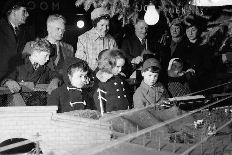 Children gather round Prince Street Station's model railway, which circled the station Christmas tree each December. Left to right Martin Butler, Marion Laing and Brian Laneghan.