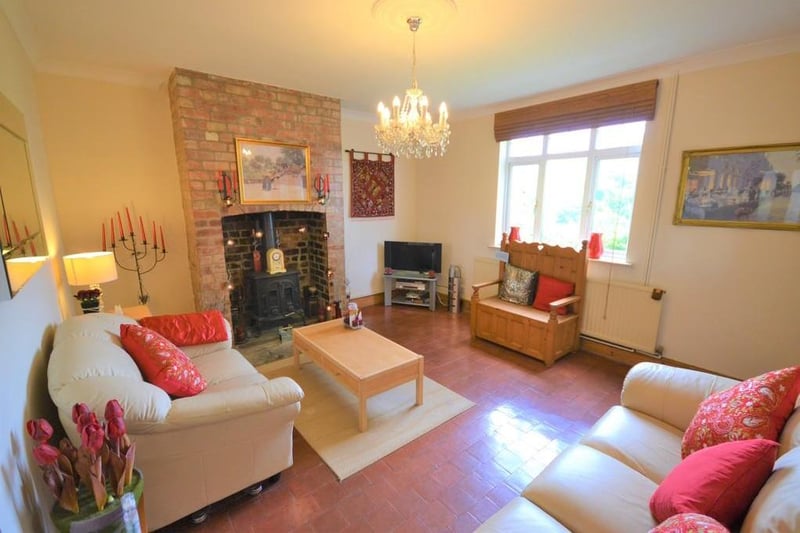 A pretty and generous sized sitting room enjoying garden views from a front facing UPVC double glazed window, the main feature is the stunning fire place with exposed brickwork, stone hearth and a period cast stove, complimented with terracotta floor tiles, and a glazed pine door open into the dining kitchen.