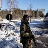 A Ukrainian border guard stands watch at a crossing between Ukraine and Belarus near Vilcha on Sunday (Picture: Chris McGrath/Getty Images)
