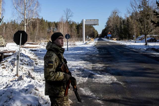 A Ukrainian border guard stands watch at a crossing between Ukraine and Belarus near Vilcha on Sunday (Picture: Chris McGrath/Getty Images)