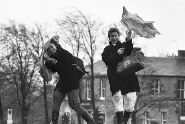 Two women struggle to put their umbrellas up in the wind and rain in Edinburgh in October 1984.