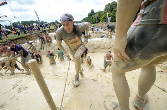 Competitors covered in mud on the 'mud mile' obstacle during a Tough Mudder event on the Badminton Estate, Wiltshire. Picture: PA
