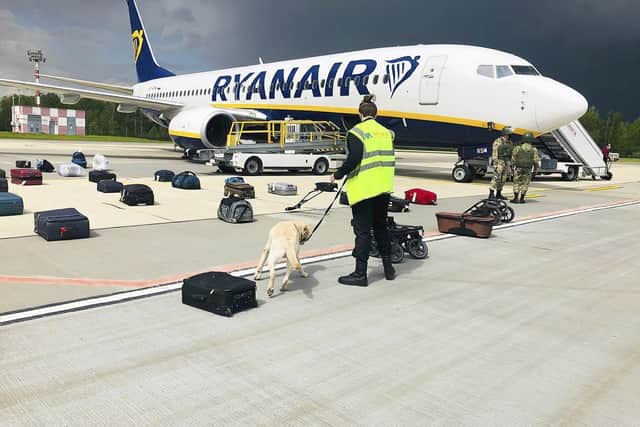 Security forces check the luggage of passengers on the Ryanair plane that was carrying opposition figure Raman Pratasevich from Athens to Vilnius, until it was forced to land at Minsk international airport (Picture: Onliner.by via AP)