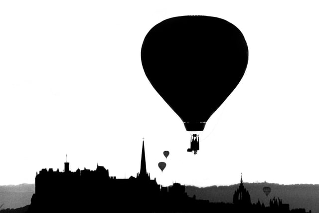 A hot air balloon rises from Holyrood Park silhouetted against the Edinburgh skyline in August 1984.