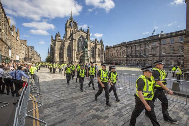 Police walk up the Royal Mile in Edinburgh, past St Giles' Cathedral where Queen Elizabeth II is lying in state. (SWNS)