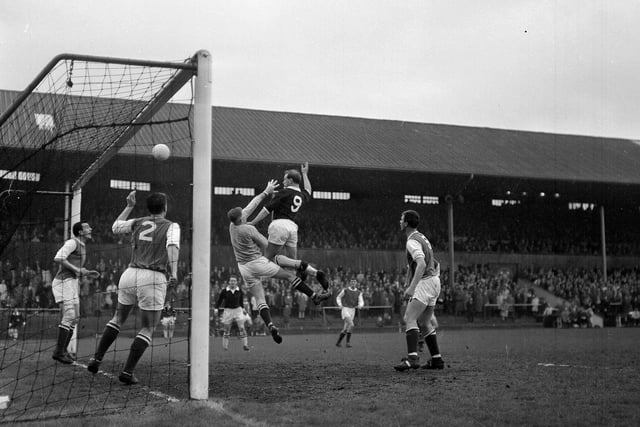 Keeper Willie Wilson and Hibs teammates mob the goalmouth as Hearts' Tommy White comes in for the attack during the Edinburgh Derby in May 1964.
