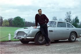 Edinburgh-born actor Sean Connery poses beside the Aston Martin DB5 in a publicity shot for the James Bond film Goldfinger.