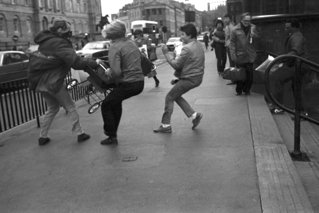 Passers-by rush to stop a baby's pushchair being blown away at Edinburgh's Waverley Steps during the gales of November 1981.