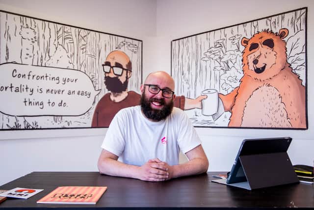 Gordon Shaw, sitting proudly in front of illustrations from his comic 'Bittersweet'.