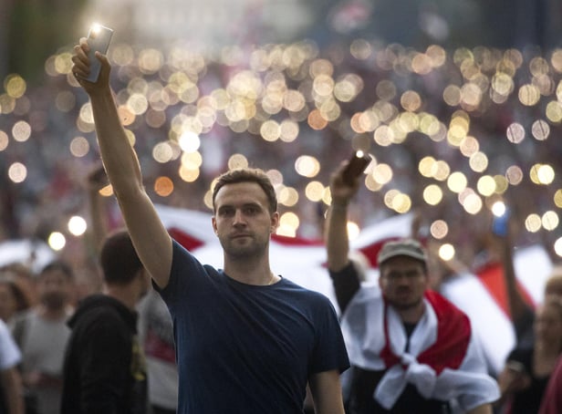 Belarusian opposition supporters light phones lights during a rally in Minsk during the fourth week of daily protests demanding the resignation of President Alexander Lukashenko (Picture: Tut.By via AP)