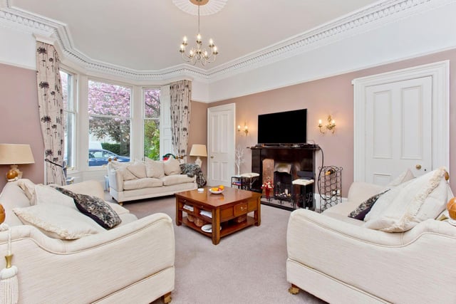 On the ground floor, there is a large living room with a bay window, highly ornate cornicing, and two press cupboards.