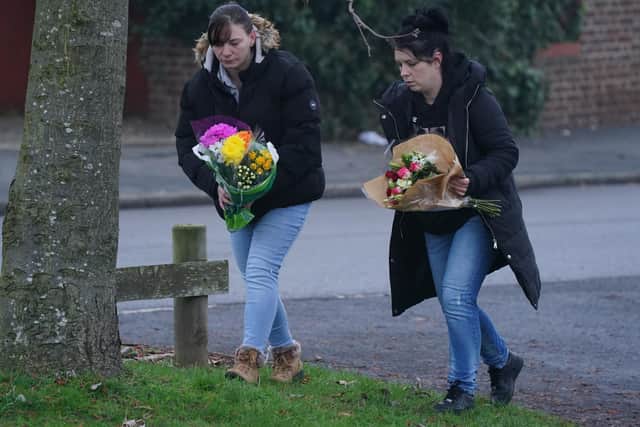 Members of the public lay flowers near to the scene in Babbs Mill Park in Kingshurst, Solihull.