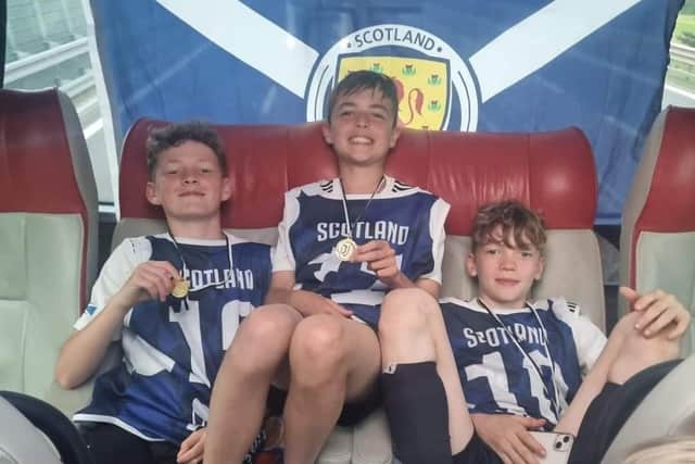 Rio (left) with two of his teammates on the Scotland coach after winning the Juventus World Cup.