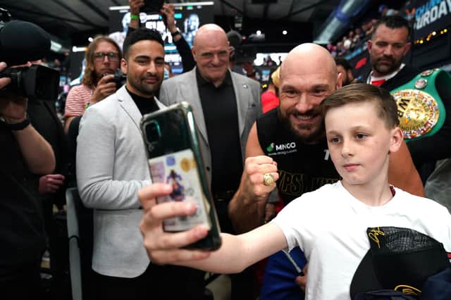 Tyson Fury takes a photo with a fan during the weigh in at BOXPARK Wembley, London.