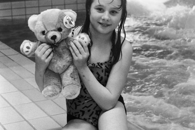 Lee McKendry (11) wins a teddy bear for being the 1,000,000th person to use the water flume at the Royal Commonwealth pool in Edinburgh, April 1989.
