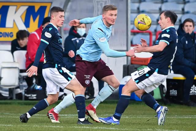 Taylor Moore is pressured by Dundee's Luke McCowan and Paul McGowan at the Kilmac Stadium